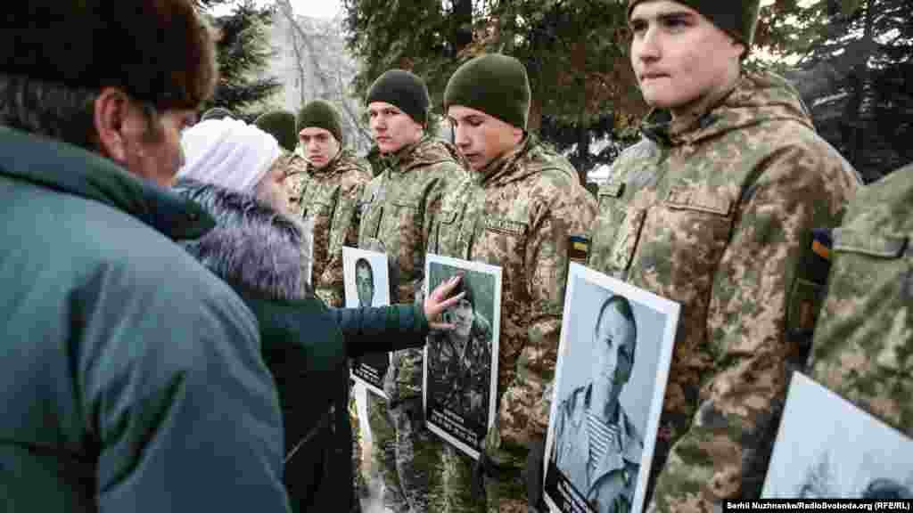 Женщина прикасается к портрету погибшего &quot;киборга&quot;