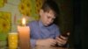 Russia -- boys have to do their school homework in the hall because of electricity outage