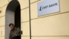 Russia -- A man walks past SMP bank signage outside their main office in Moscow, March 24, 2014